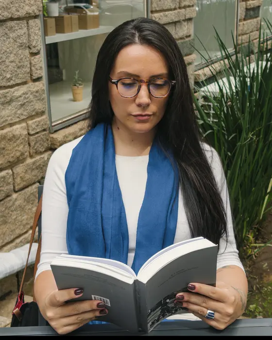 Ana Vitória Baron lendo um livro ao ar livre
